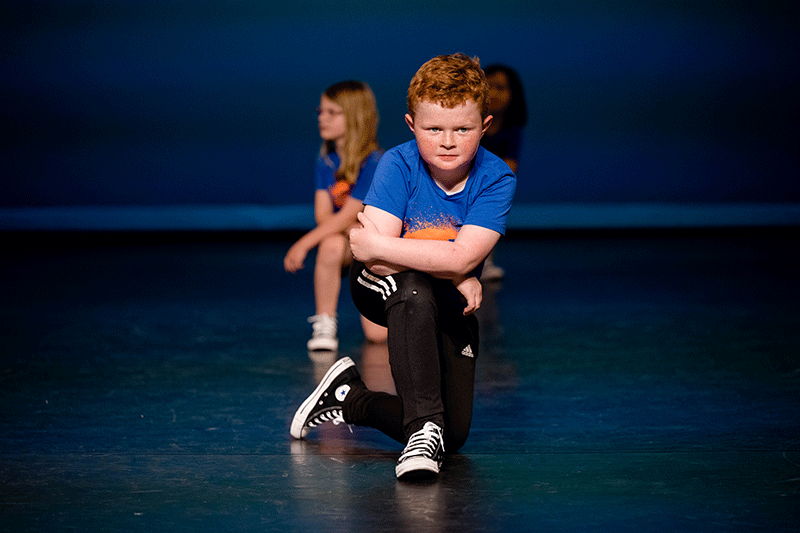 young male hip hop dancer posing on stage